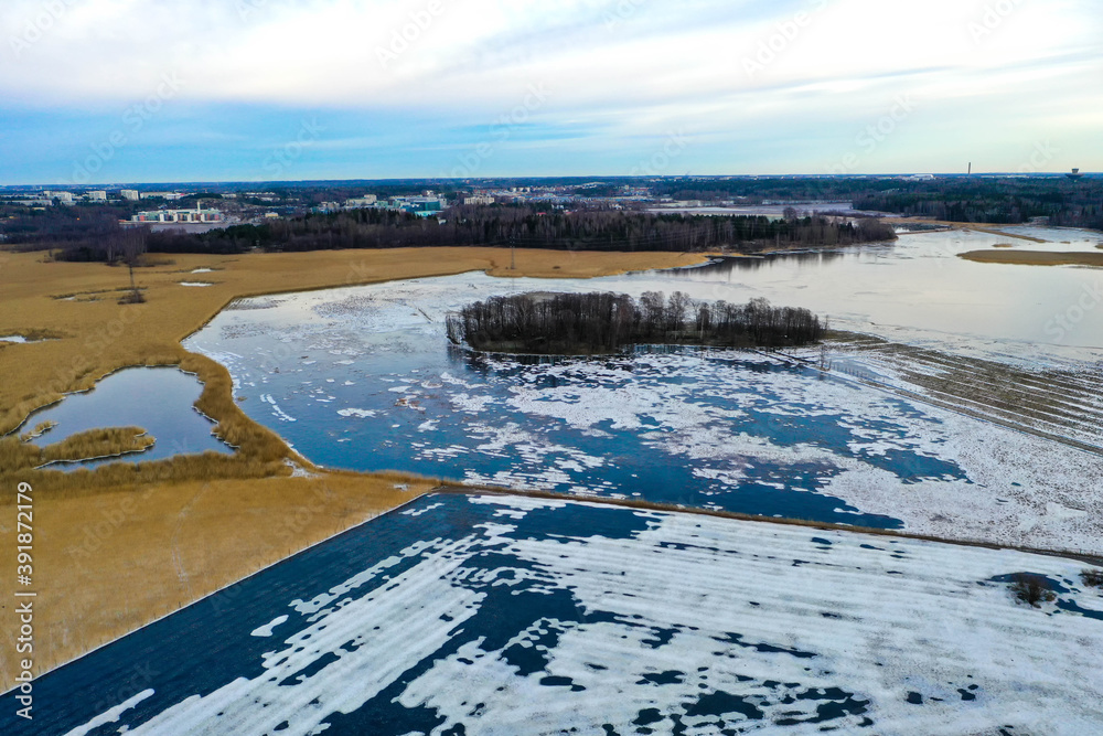 Aerial view of frozen water and snowy nature in Lammassaari, Helsinki, Finland