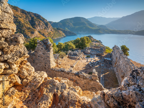 morning lights on walls of antique temple on turkish island Gemilie with sea and mountains view