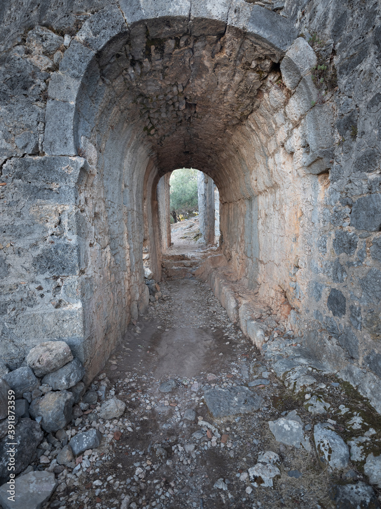Obraz premium view to stone tunnel of antique city on island Gemilie in Turkey