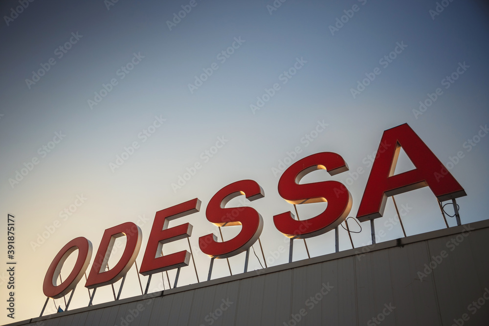 Odessa city name sign on the top of a sea port building with a blue sky at a background. Odessa city name sign on the top of a sea port building with a blue sky at a background.