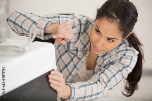 happy female worker repairing air conditioner