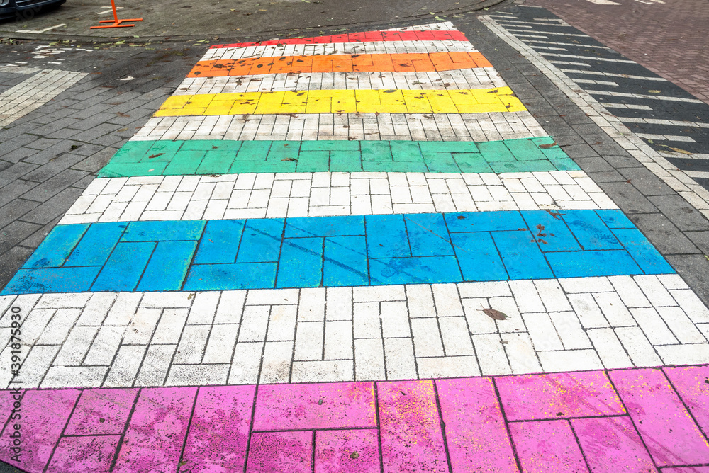 Pedestrian crossing painted in rainbow colours in a city centre. Rights of LGTBs concept.