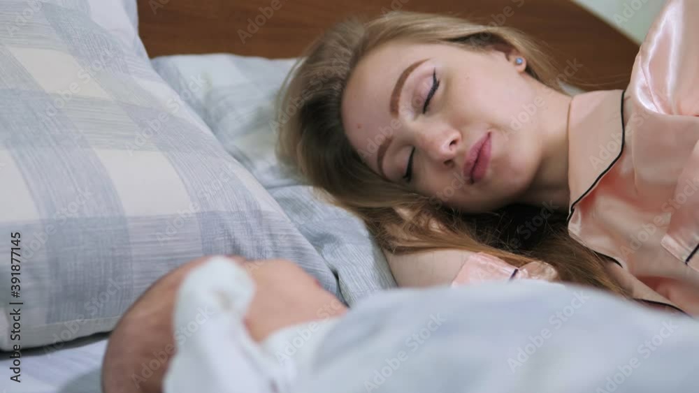 Happy mother and her newborn baby resting in bed together. Maternity concept. Parenthood Happy mother and her newborn baby resting in bed together. Maternity concept. Parenthood