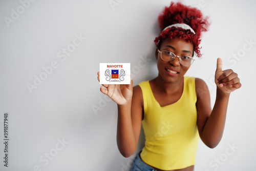 African woman with afro hair, wear yellow singlet and eyeglasses, hold Mayotte flag isolated on white background, show thumb up. photo