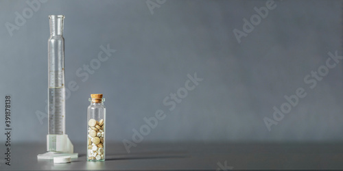 Mix of medical pills in a glass jar on a gray background. Medical and health care concept. Selective focus.