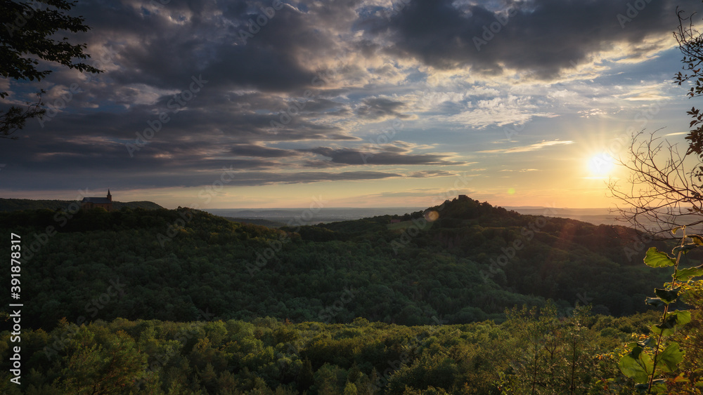 Fototapeta premium Romantische fränkische Sommerlandschaft im Abendrot in Bayern in Oberfranken bei Sonnenuntergang in den Hügeln
