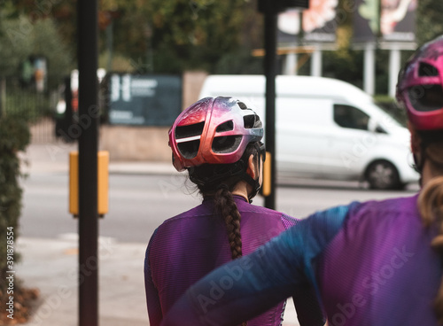 Road cyclist in purple kit waiting at traffic lights