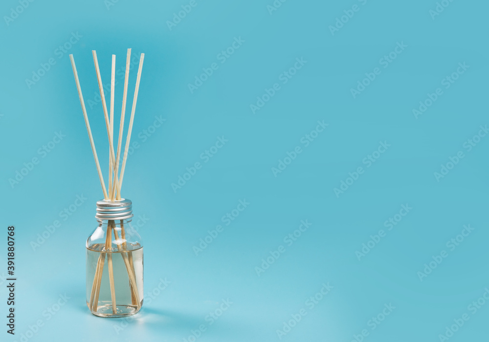 home fragrance in a glass diffuser with wooden sticks on a blue background