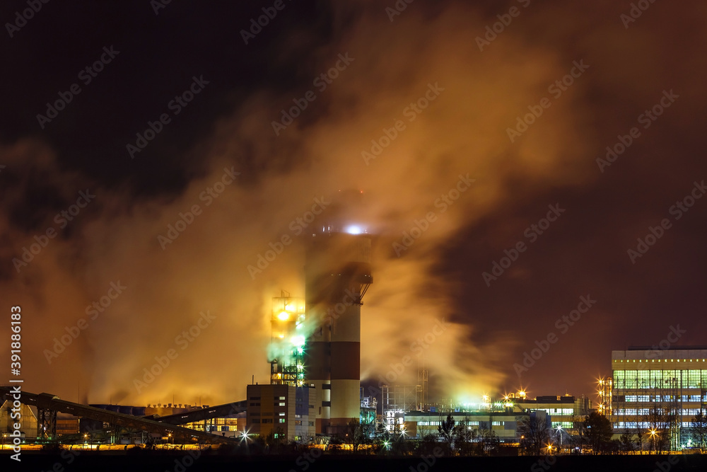 night industrial landscape environmental pollution waste of thermal power plant. Big pipes of chemical industry enterprise plant