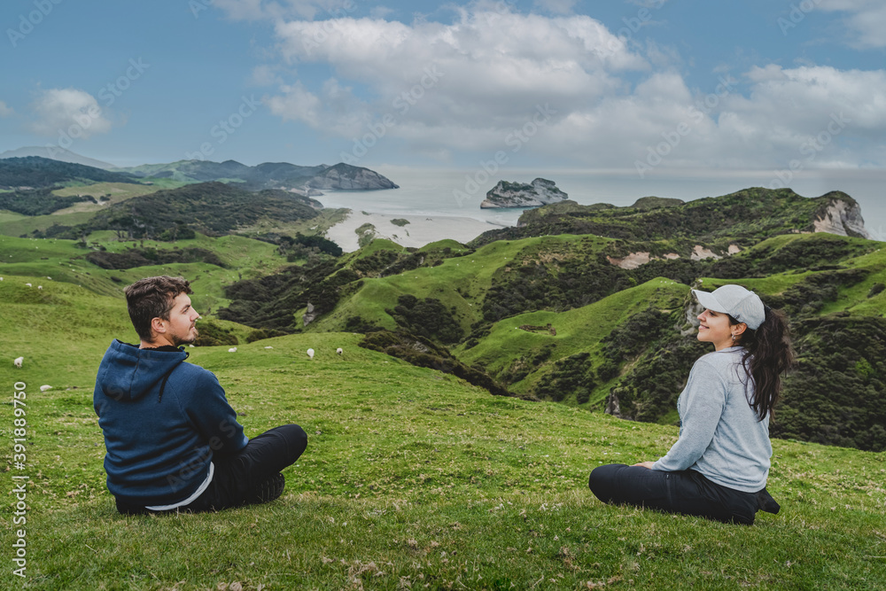 Couple looking each other at Wharariki Beach view point, New Zealand