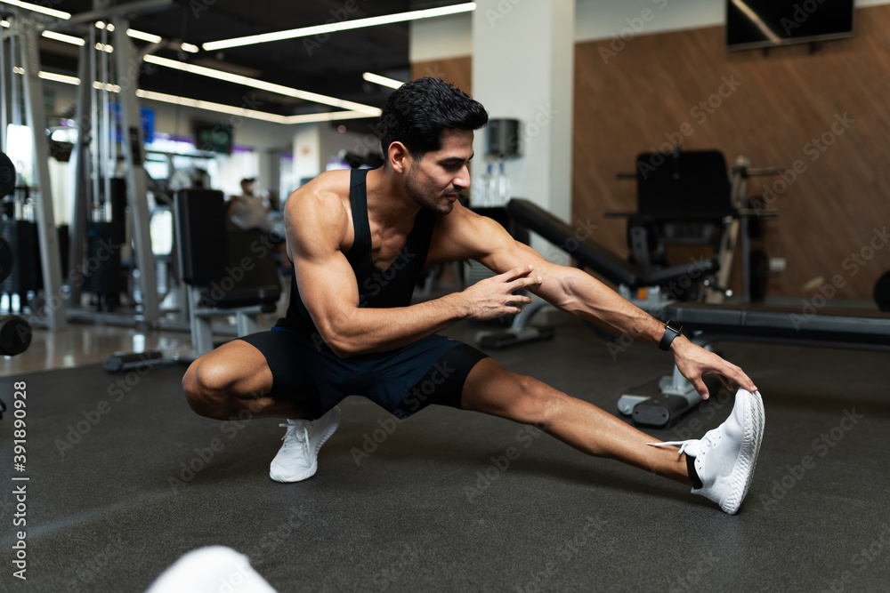 Handsome man stretching before exercising Handsome man stretching before exercising
