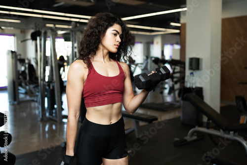 Latin young woman working out with two weights