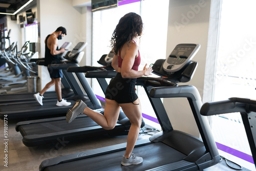 Athletic woman in her 20s running on a machine