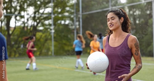 Female soccer player talking with teammate during practise