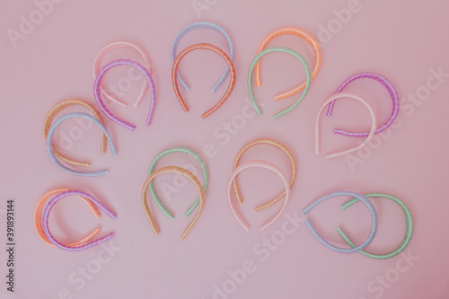 Many colorful tiaras. Studio photo with pink background.