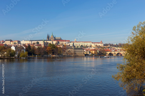 Autumn colorful Prague Lesser Town with gothic Castle and Charles Bridge above River Vltava in the sunny Day, Czech Republic © Kajano