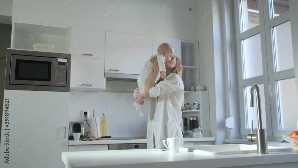 mom is spinning with the baby in the kitchen with a bright interior mom is spinning with the baby in the kitchen with a bright interior