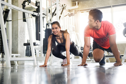 Attractive male and female couple exercising in the gym