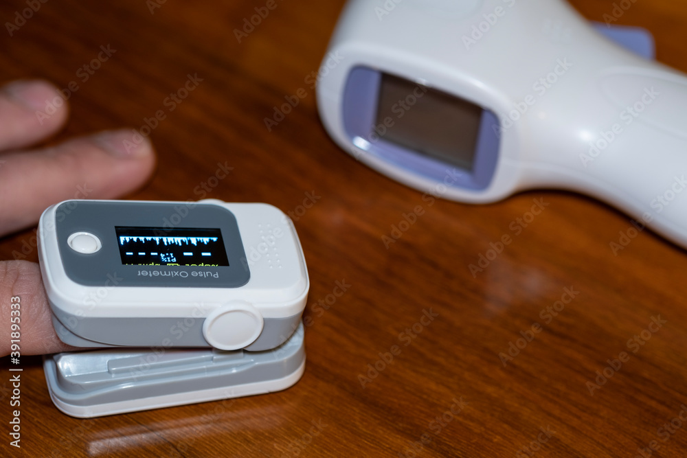 Man using pulse oximeter to measure oxygen saturation in covid19 pandemic  disease,medical home monitoring treatment Stock Photo | Adobe Stock