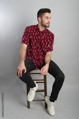 Fototapete Young model with red shirt, piercings and fledgling beard