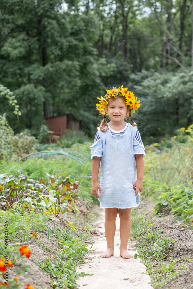 © Angelina - Little, cute girl in the village in a blue sundress and with a wreath of yellow flowers on her head © Angelina - Little, cute girl in the village in a blue sundress and with a wreath of yellow flowers on her head