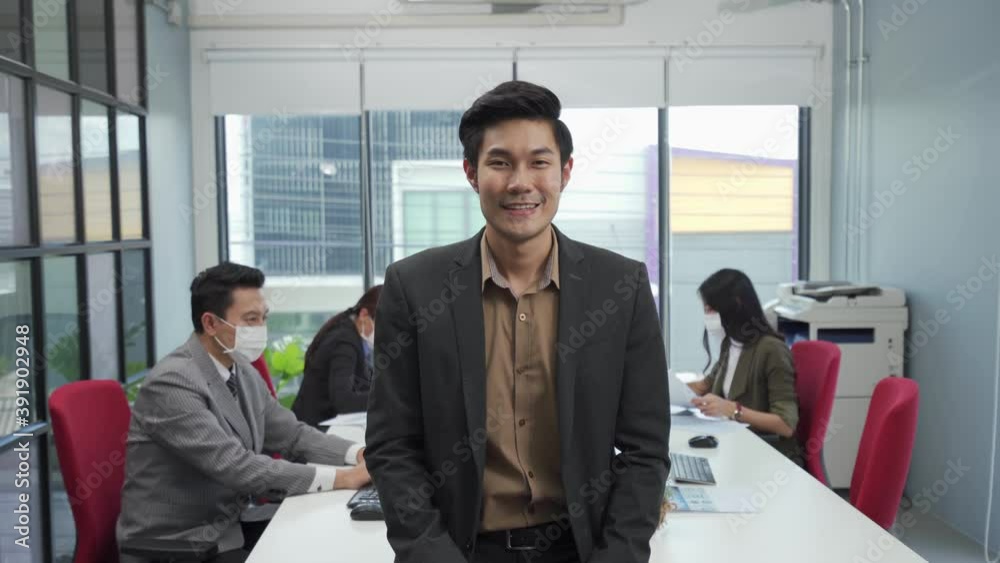 Asian businesspeople take off face mask and smile with confident Asian businesspeople take off face mask and smile with confident