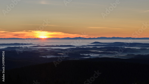 Inversion in the valley during sunrise with mountain ridge in the background. © Radek Vicar