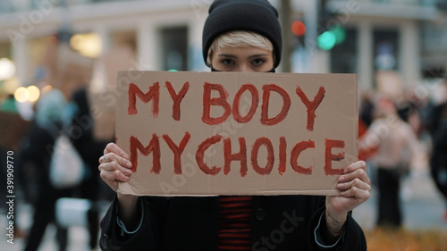Woman holding a sign My Body, My Choice. Protest against tightening of the abortion law . Nationwide women's strike. Wearing protective face mask against COVID-19 Coronavirus. High quality photo photo