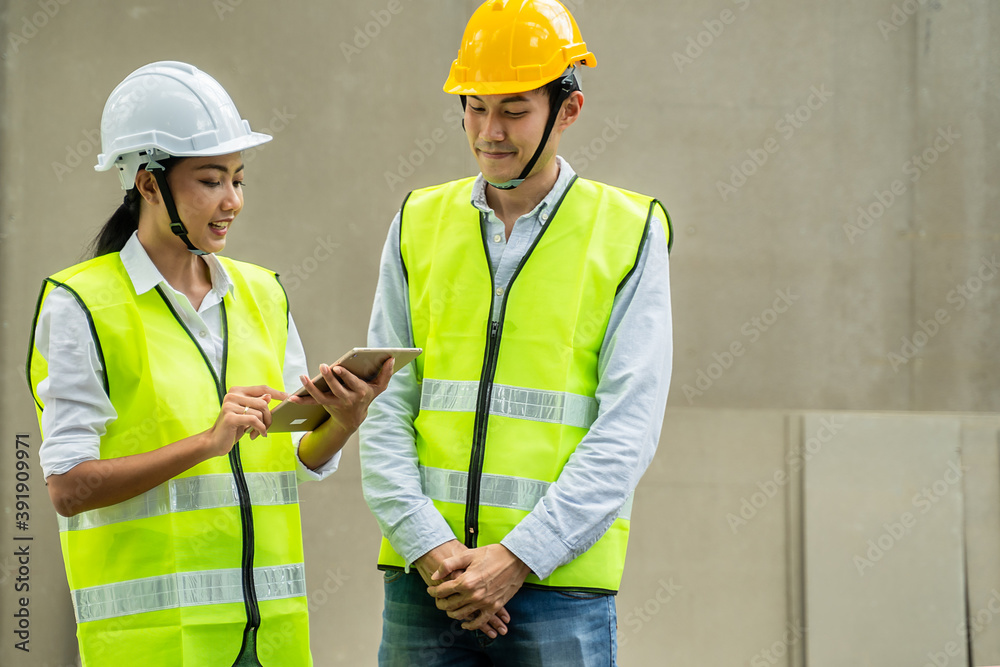 Asian young female engineer explaining job on tablet to male worker. Asian young female engineer explaining job on tablet to male worker.