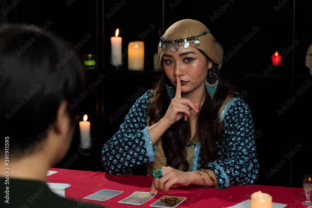 Φωτογραφία Portrait of Asian beautiful Gypsy fortune teller woman in dark room acting quiet