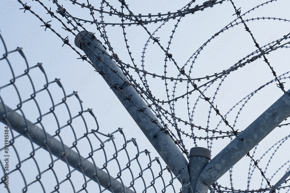 Restricted area barbed military base. Barrier border. Boundary security wall with sunset Restricted area barbed military base. Barrier border. Boundary security wall with sunset