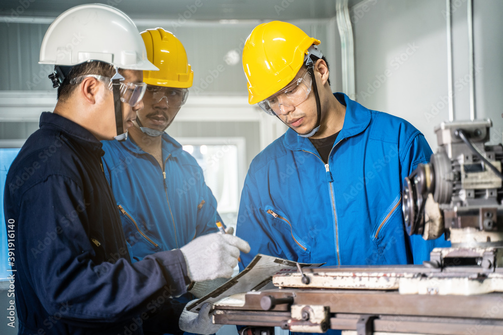 Asian engineer man training his worker for process of heavy machine. Asian engineer man training his worker for process of heavy machine.