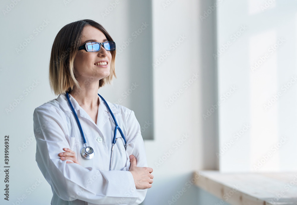 professional doctor woman with glasses near window and stethoscope professional doctor woman with glasses near window and stethoscope