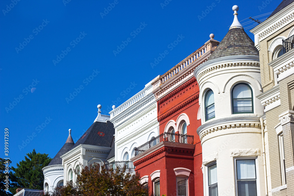 A row of townhouses in Washington DC on early morning in autumn, USA. Suburban neighborhood of US capital city under blue sky.