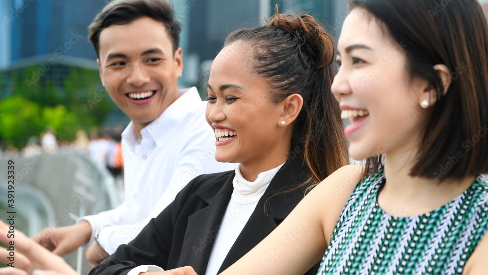 Obraz premium Three asian young friends standing outdoor in the city talking, smiling and enjoying city life