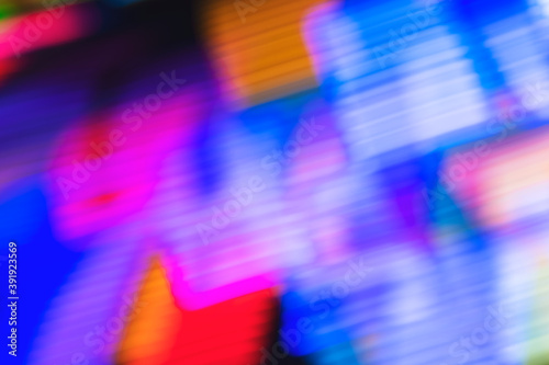 Defocused colorful neon lights from an amusement park background