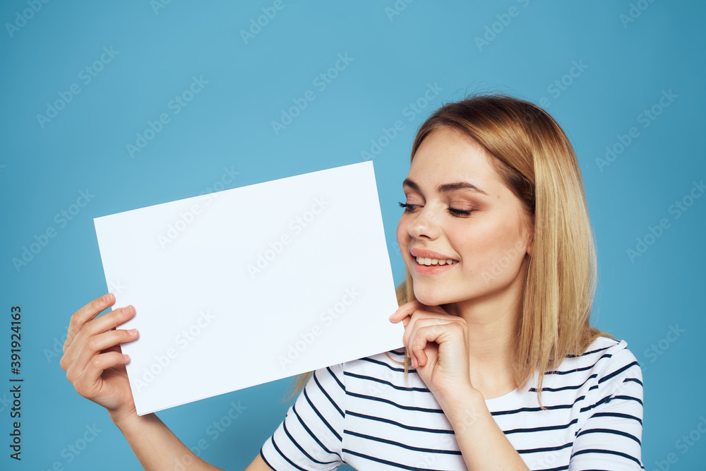 Woman holding sheet of paper striped T-shirt Copy Space cropped view blue background Woman holding sheet of paper striped T-shirt Copy Space cropped view blue background
