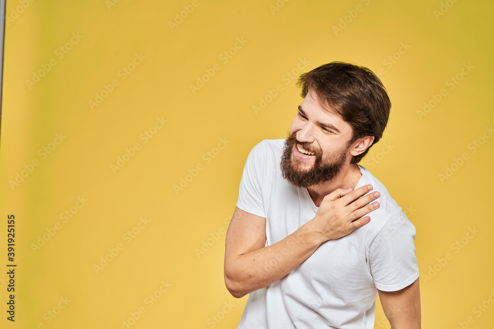 Man gesturing with hands emotions lifestyle white t-shirt yellow isolated background Man gesturing with hands emotions lifestyle white t-shirt yellow isolated background
