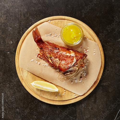 Perch served on piece of parchment and wooden board