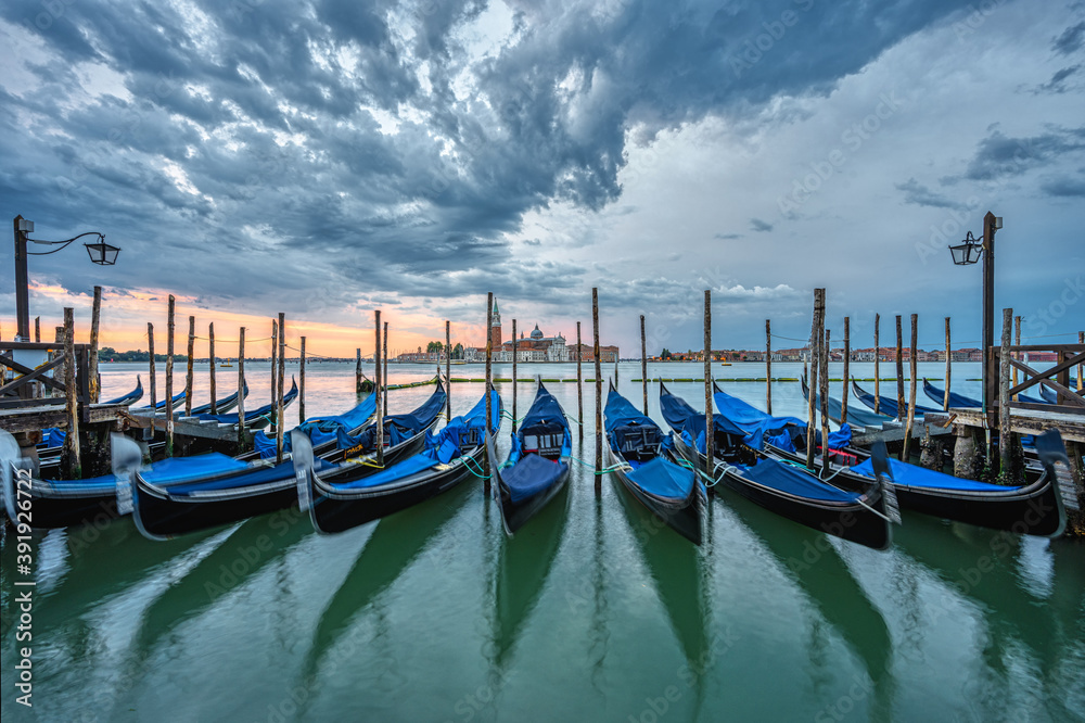 Gondolas at the St. Marks square in Venice, Italy, before a dramatic sunrise