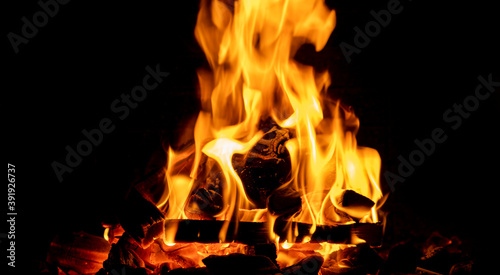 Hot fireplace full of wood. Real Flames from burning logs texture background. Fireplace background. Fire flame close up... © Aleksei