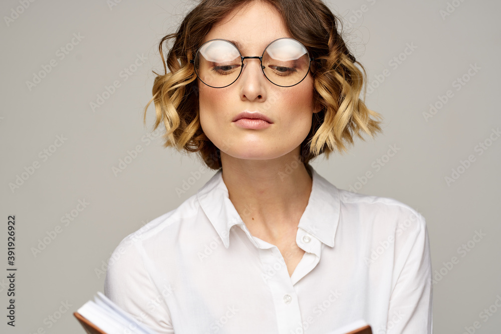 Business woman with notepad and glasses on a light background hairstyle success emotions Business woman with notepad and glasses on a light background hairstyle success emotions