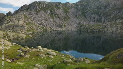 Scenic reflection of mountains and clouds in small lake in Italy.  Peace and tranquility in Alps and Dolomites. 
Lake Nero/Lago Nero, Carisolo, Trentino, Italy. photo