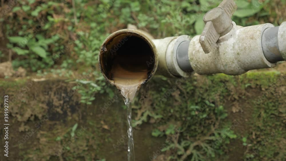 Shot of a large water drain container with waste water flowing out the pipe on plantation factory Sierra Nevada Colombia slowmotion Shot of a large water drain container with waste water flowing out the pipe on plantation factory Sierra Nevada Colombia slowmotion