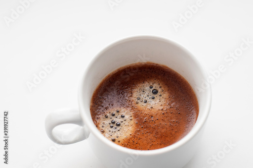 Cup of freshly brewed coffee on white background