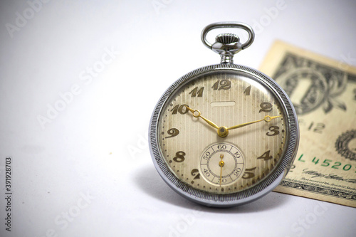 Pocket watch and 1 dollar banknote