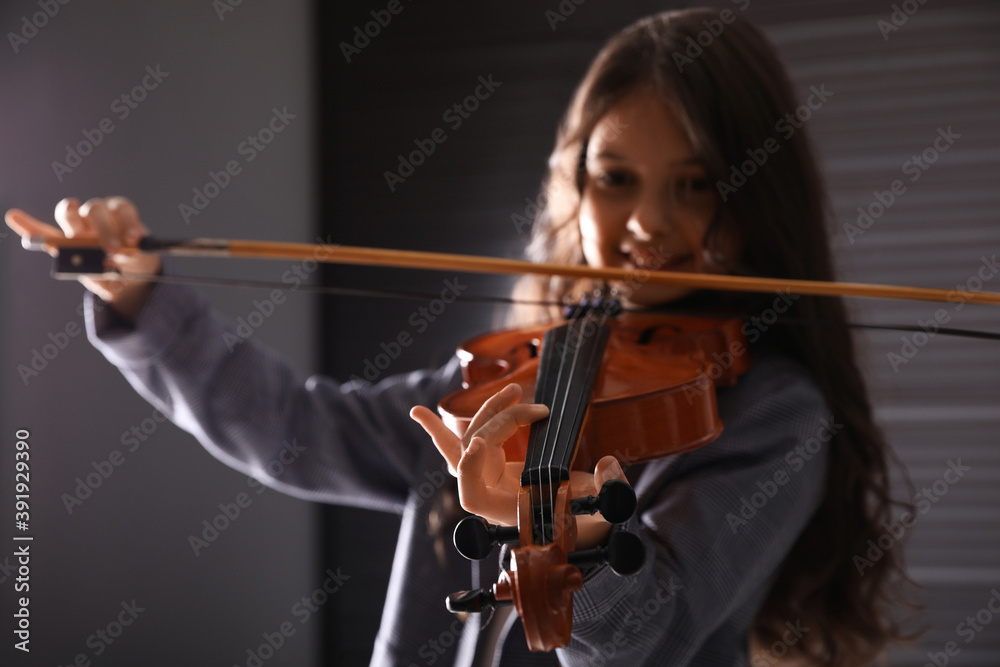 Preteen girl playing violin in studio at music lesson, focus on hand Preteen girl playing violin in studio at music lesson, focus on hand