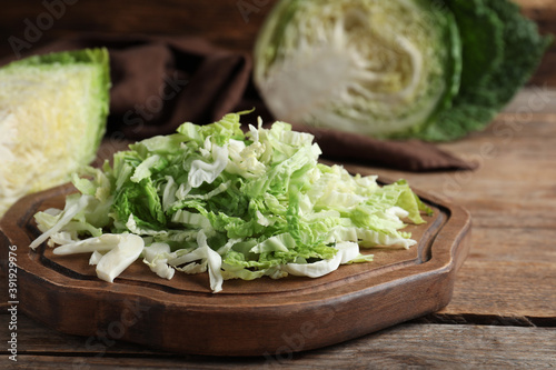 Cut fresh savoy cabbage on wooden table, closeup