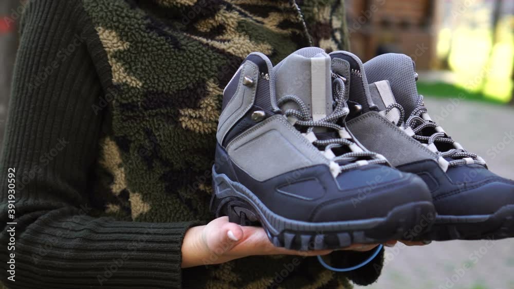 Unrecognizable woman carries men's boots Unrecognizable woman carries men's boots