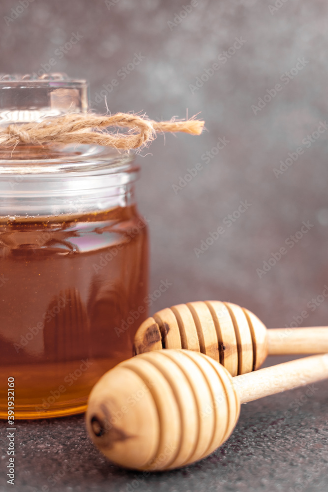 Glass can full of honey and wooden stick Glass can full of honey and wooden stick